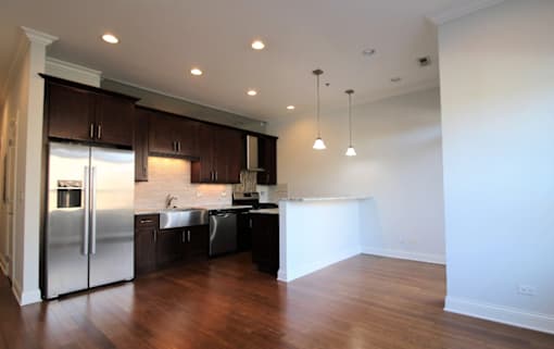 a renovated kitchen with stainless steel appliances and wooden floors