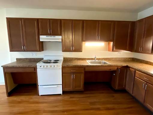 A kitchen with brown cabinets and a white stove.