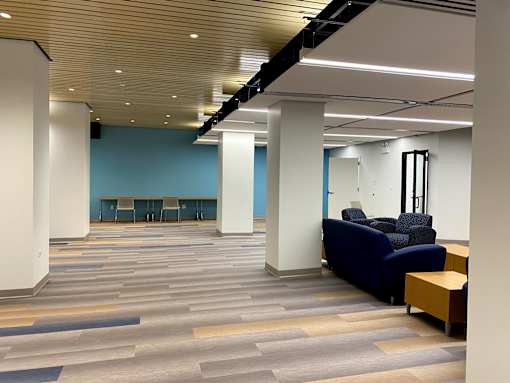 A room with a blue wall and a long table with chairs.