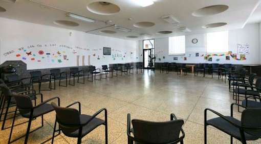 A room with black chairs and a white wall with drawings and writings on it.