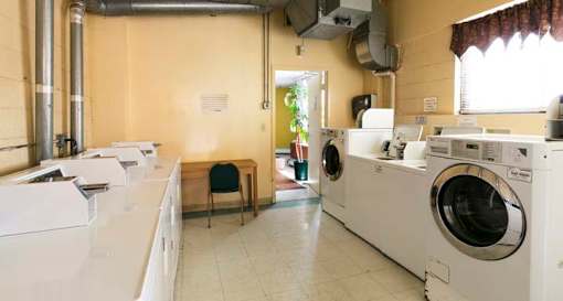 A laundromat with washers and dryers and a table in the middle.