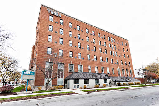 A tall red brick building with the word "YMCA" on the top.