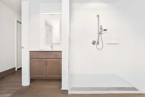 a white bathroom with a shower and a sink