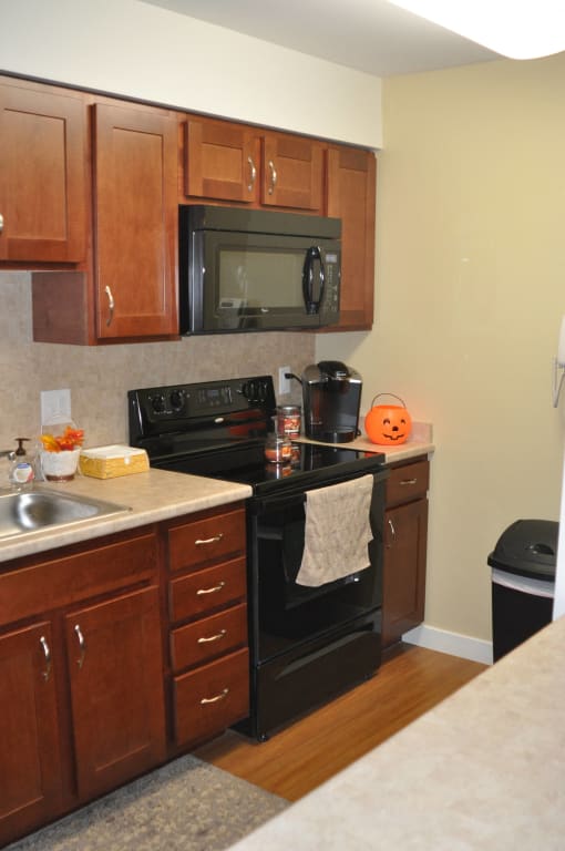 a kitchen with black appliances and wooden cabinets