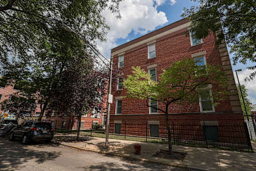 A red brick building with a tree in front of it.