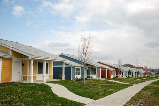 a row of houses in a neighborhood with grass and a sidewalk