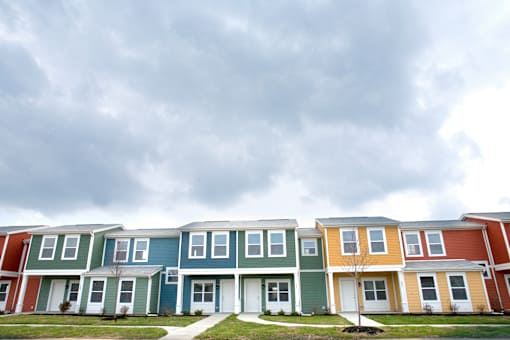 a row of houses in front of a cloudy sky
