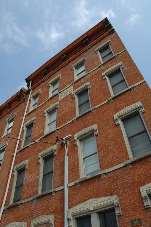 a tall brick building with windows and a street light