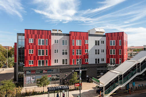 A red and white building with a green staircase in front.
