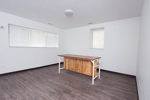 A room with a wooden table and two windows.