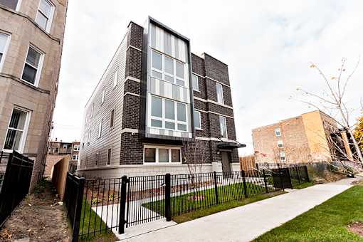 A modern house with a black fence in front.