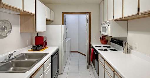A kitchen with white cabinets and a white counter top.