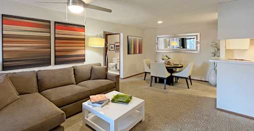 Spacious living room with woodburning fireplace and dining room area at Tanglewood Apartments in Lincoln Nebraska
