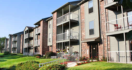 Green and red brick exterior, beautiful landscaping, scenic views, lots of trees, and spacious balconies at LionsHead Apartments in Omaha, Nebraska
