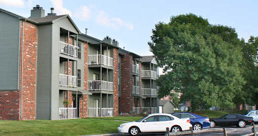 Green and red brick exterior, beautiful landscaping, scenic views, lots of trees, and spacious balconies at LionsHead Apartments in Omaha, Nebraska