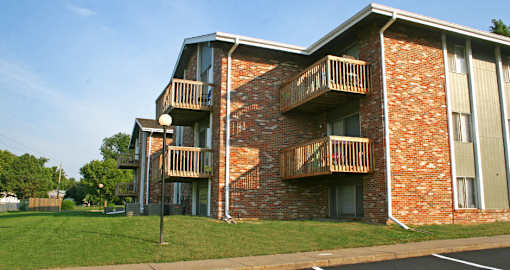 Apartments in La Vista with brick exteriors, park-like setting, scenic views, and lots of trees at The Inverness Apartments