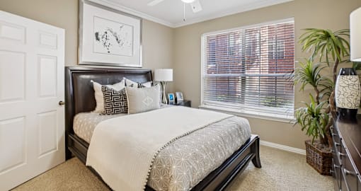 A bedroom with a large bed and a picture on the wall.