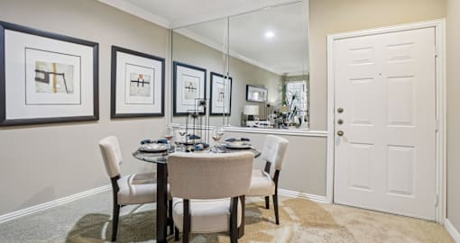 A dining room with a table set for four.