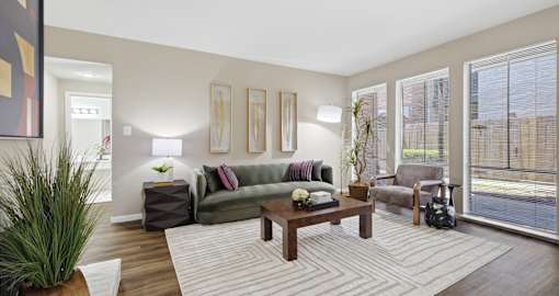 A living room with a couch, a coffee table, and a potted plant.