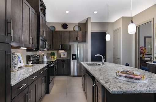 Luxury apartments with spacious floor plan, granite countertops, stainless steel appliances, built-in wine rack, kitchen island, and porcelain tile floor at Xenia Apartments in Golden Valley, Minnesota