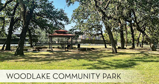 A gazebo sits in the middle of a park with trees surrounding it.