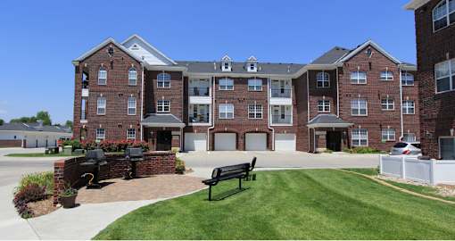 Luxury apartments with red brick exteriors, resident grilling station, and attached garages at Rockledge Oaks Apartments in Lincoln, Nebraska