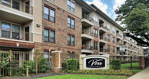 Luxury apartments with brick exteriors, two swimming pools, parking garage, and fitness center at The Voss Apartments in Houston.