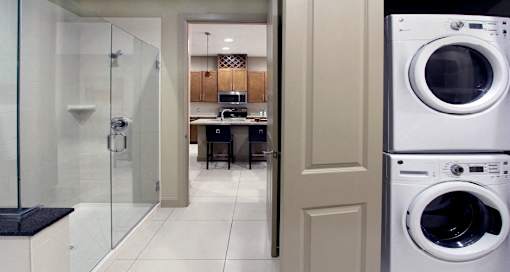 Luxury apartments with front-loading washer and dryer, glass shower, and separate oval soaking tub at Bellemeade Apartments in west Des Moines
