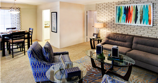 Spacious living room and dining room with white brick feature wall at Plantation apartments near the Galleria in Houston.