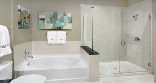 Luxury bathroom with oval soaking tub, glass shower, granite countertops and linen closet at Bellemeade Apartments in west Des Moines