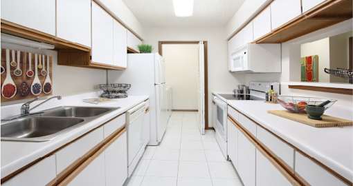 Bright white kitchen with lots of cabinet space, lots of counter space, and full-size washer and dryer in unit at LionsGate Apartments in Lincoln, Nebraska