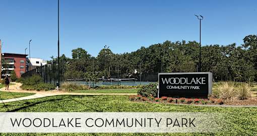 A sign for Woodlake Community Park is displayed in front of a building.