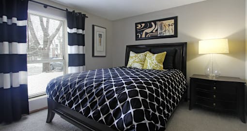 Spacious master bedroom with walk-in closet, master bathroom, and gray wall color at The Vanderbilt Apartments in Omaha, Nebraska