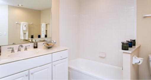 Bathroom with white cabinets, soaking tub, and tiled floor at Embassy Park Apartments in Omaha, Nebraska