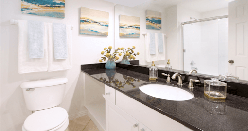 Luxury bathroom with oval soaking tub with glass enclosure, granite vanity top, and glass shower at Tuscany Row Townhomes in Houston.