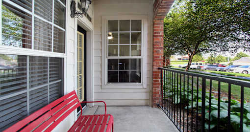 Luxury apartments with red brick exterior, spacious balconies, lush landscaping, and scenic views at Lenox Village Apartments in Lincoln, Nebraska