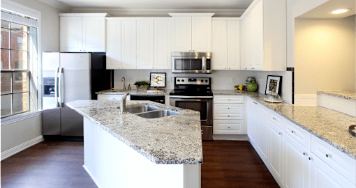 Spacious kitchen with island, granite countertops, custom home cabinets, French doors, smooth glass top stove, spacious pantries, breakfast bar and stainless-steel appliances at Tuscany Row Townhomes in Houston.