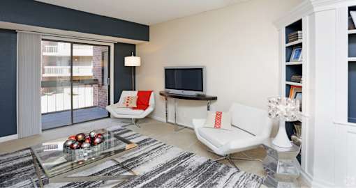 Spacious living room with colored feature wall and built-in shelves at Embassy Park Apartments in Omaha, Nebraska