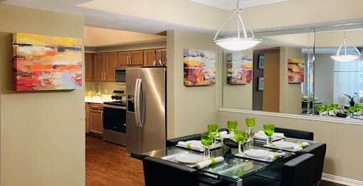 Spacious dining room with 9-foot ceilings, mirror accent wall, stainless steel appliances, side-by-side refrigerators at The Lanesborough Apartments in Houston.