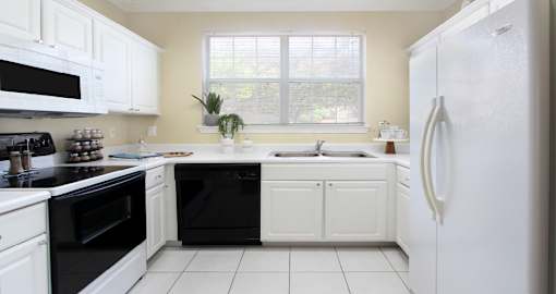 Spacious u-shaped kitchen, luxury apartments with bright white kitchen and side-by-side refrigerator at Saddlebrook apartments in Urbandale, Iowa