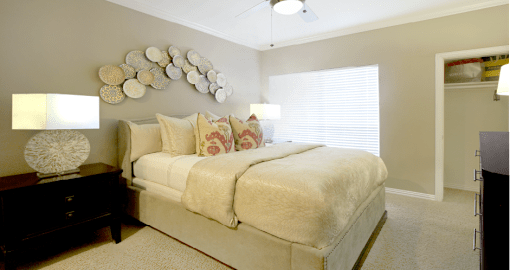 Spacious bedroom with walk-in closet and ceiling fan at Tuscany Lane Apartments in Houston.