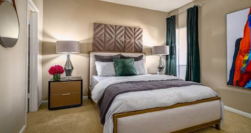 Spacious bedroom with walk-in closet and cozy grey wall color at Woodlake Oaks Apartments in Houston.