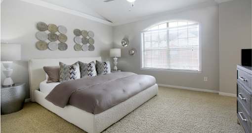 Huge master bedroom, spacious master bedroom with ceiling fan, high vaulted ceiling, over-sized windows, walk-in closet and attached luxury bath suite at Tuscany Villas in Houston.