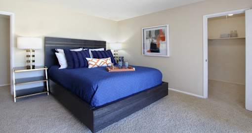 Spacious bedroom with walk-in closet, access to balcony and lots of natural light at Alpine Village Apartments in La Vista, Nebraska