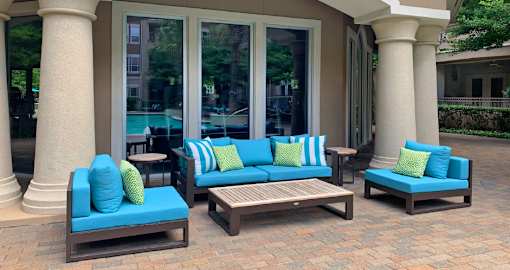 Luxury apartments with palm trees, spacious sundeck with poolside lounge chairs and fountains at Villa Piana Apartments in Dallas