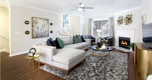 Spacious living room with wood plank flooring and wood-burning fireplace at Tuscany Villas Townhomes in Houston.