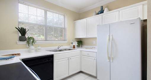 Luxury apartments with bright white kitchen, u-shaped kitchen, white cabinets, and side-by-side refrigerator at TurtleCreek apartments in West Des Moines, Iowa