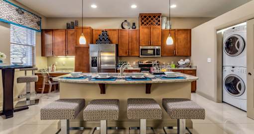 Luxury apartments next to the Galleria in Dallas with spacious floor plan, granite countertops, stainless steel appliances, built-in wine rack, kitchen island, front-loading washer and dryer and porcelain tile floor at Villa Piana Apartments in Dallas