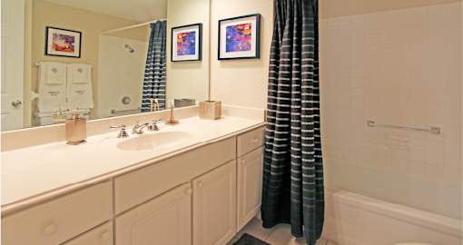 Bathroom with white cabinets, lots of cabinet space, soaking tub, and tiled floor at Embassy Park Apartments in Omaha, Nebraska