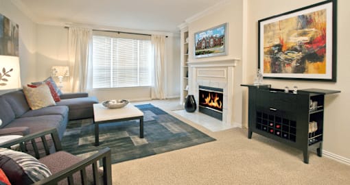 A living room with a fireplace and a painting on the wall.
